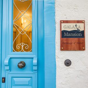 niebieskie drzwi z znakiem na boku budynku w obiekcie Galaxa Mansion w mieście Galaxidi