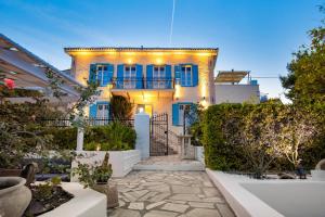 a white house with blue windows and lights on it at Galaxa Mansion in Galaxidi