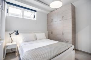 1 dormitorio con cama blanca y ventana en Supreme B1 Apartment in Syntagma, en Atenas