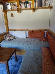 a room with two beds and a table and bookshelves at Appartement situation idéale Briançon tout confort in Briançon