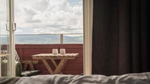 einen Balkon mit einem Tisch und einem Fenster mit Aussicht in der Unterkunft Siljansnäs Hotell in Siljansnäs