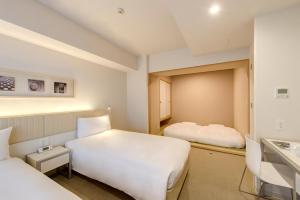 Cette chambre comprend 2 lits et un lavabo. dans l'établissement Citadines Kyoto Karasuma-Gojo, à Kyoto