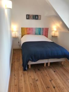 ein Schlafzimmer mit einem Bett mit einer blauen Decke in der Unterkunft Maison avec terrasse vue sur ria d'Etel - moulin du Sac'h in Étel