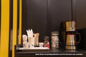 a counter with a coffee maker and other items on it at Panda Pod Hotel in Richmond