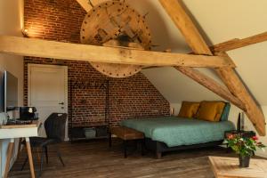a bedroom with a bed and a brick wall at Hofstede Ter Biest in Zwalm