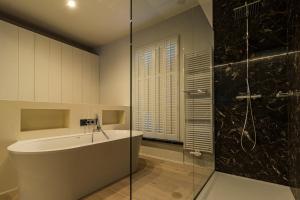 La salle de bains est pourvue d'une douche, d'une baignoire et d'un lavabo. dans l'établissement Hofstede Ter Biest, à Zwalm