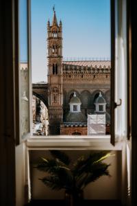 einen Blick auf den Glockenturm von London aus einem Fenster in der Unterkunft Suite Cathedral Palermo in Palermo