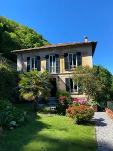 a house with a palm tree in front of it at B&B Villa le Ortensie in Faggeto Lario 