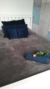 a bed with a blue blanket and flowers on it at Apartament Kuba in Warsaw