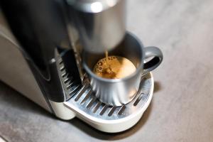 a coffee maker is making a cup of coffee at Oreo Apart Hotel in Mamaia Sat/Năvodari