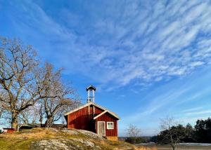 a red barn with a cross on top of a hill at Taattisten Tila - Taattinen Farm and Cottages in Naantali