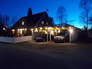 une maison avec des voitures garées dans un garage la nuit dans l'établissement Lilla Stugan, Sjötorp, à Mariestad