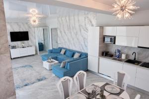 a living room with a blue couch and a kitchen at 5 stars 301 frontal sea view apartment in Mamaia Sat/Năvodari