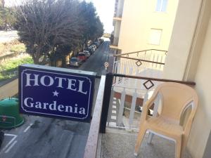 a sign for a hotel gardenia on a balcony with a chair at PENSIONE GARDENIA in Finale Ligure