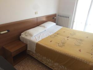 a bedroom with a bed with a wooden head board at PENSIONE GARDENIA in Finale Ligure