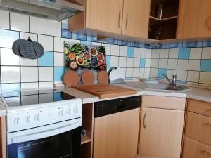 a kitchen with a white stove top oven next to a sink at Ferienwohnung Karoline Eisenach in Eisenach +9 photos
