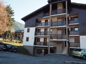 een gebouw met balkons en auto's geparkeerd op een parkeerplaats bij Appartement idéal été ou hiver, pour skieurs et promeneurs, 4 personnes in Saint-Gervais-les-Bains
