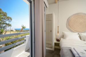 a bedroom with a view of the ocean at Africanis Suites in Schinoussa