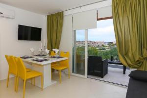 ein Esszimmer mit einem Tisch und gelben Stühlen in der Unterkunft Apartment in Tribunj with sea view, balcony, air conditioning, WiFi 4953-3 in Tribunj
