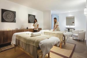 two women standing in a massage room with beds at Hotel Riu Costa del Sol - All Inclusive in Torremolinos