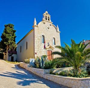 a church with a clock tower on top of it at Apartment in Tribunj with sea view, balcony, air conditioning, WiFi 4953-4 in Tribunj