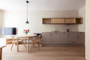cocina y comedor con mesa y sillas en Mondschein Apartments, en Lana