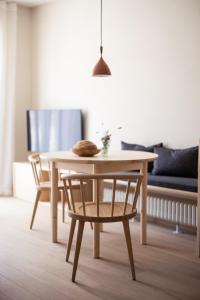 una mesa de madera y sillas en la sala de estar. en Mondschein Apartments, en Lana