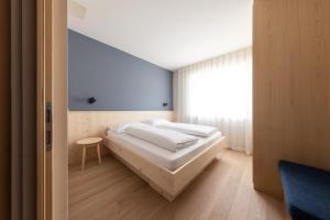 een slaapkamer met een bed en een raam bij Mondschein Apartments in Lana