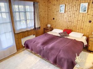 ein Schlafzimmer mit einem Bett mit einer lila Decke in der Unterkunft Chalet Belle Poncke in Nendaz