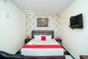 a bedroom with a bed and a tv on the wall at RedDoorz near Uniska Banjarmasin in Banjarmasin