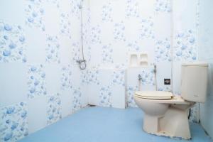 a bathroom with a toilet and blue and white tiles at RedDoorz near Uniska Banjarmasin in Banjarmasin +35 photos