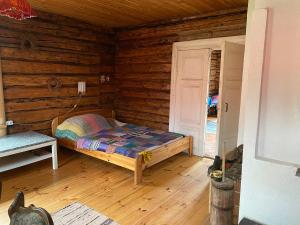 een slaapkamer met een bed in een blokhut bij Bondari - countryside experience near Rēzekne in Reiki