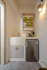 a kitchen with a sink and a refrigerator at Africanis Suites in Schinoussa