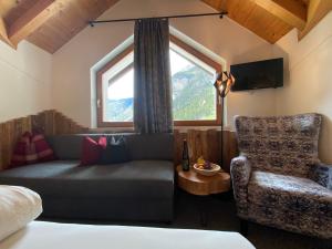 ein Wohnzimmer mit einem Sofa und einem Stuhl in der Unterkunft Hotel Jägerhof in Kaunertal