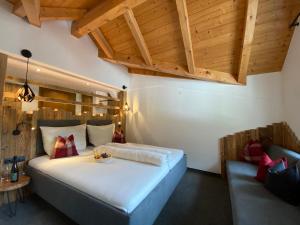 ein Schlafzimmer mit einem großen weißen Bett und einem Sofa in der Unterkunft Hotel Jägerhof in Kaunertal