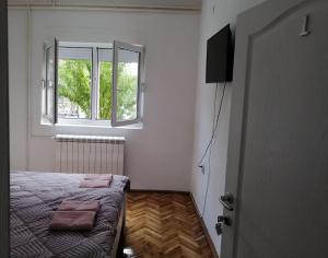- une petite chambre avec un lit et une fenêtre dans l'établissement Apartman Nana Jagodina, à Jagodina