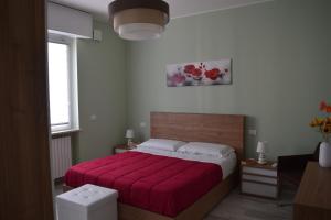 a bedroom with a bed with a red blanket at Il Portico in Peschiera del Garda