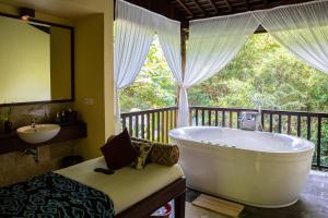a bathroom with a large tub and a sink at Komaneka at Bisma Ubud in Ubud