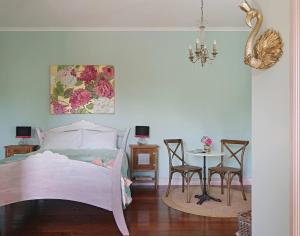 a bedroom with a bed and a table with chairs at The Spotted Chook and Amelie's Petite Maison in Montville