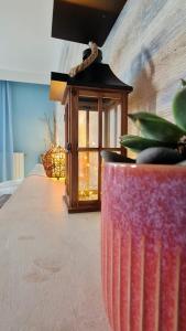 a table with a lamp and a vase with a plant at Oasis Beach Studios in Sunny Beach