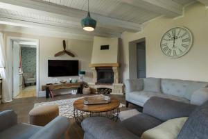 a living room with couches and a clock on the wall at Puhek breg in Krapina