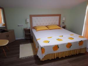 ein Schlafzimmer mit einem großen Bett mit gelben und orangefarbenen Kissen in der Unterkunft Villa Leyland in Golem