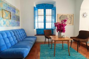 een woonkamer met een blauwe bank en een tafel bij Bohemian Villa - Málaga in Alora