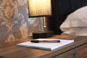 a pen on a napkin on a table with a lamp at Glyn Valley Hotel in Llansantffraid Glyn Ceiriog