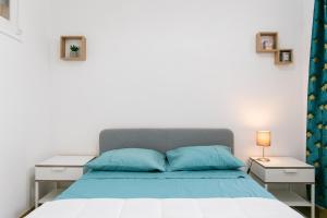 a bedroom with a bed with blue pillows at Cozy Flat at Lisboa in Lisbon