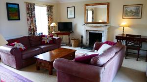 a living room with two couches and a fireplace at Arndean Cottages in Dollar