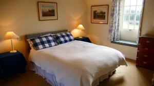 sypialnia z białym łóżkiem i 2 lampami w obiekcie Arndean Cottages w mieście Dollar