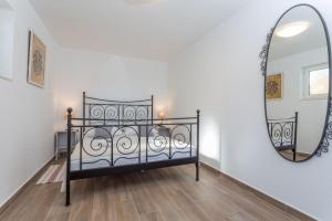 een slaapkamer met een bed en een spiegel bij NoMADS in Hvar
