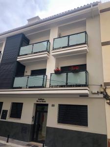 ein weißes Gebäude mit Glasbalkonen darauf in der Unterkunft La Rosa Apartment Los Boliches Fuengirola Malaga Spain in Fuengirola