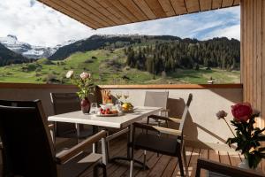 a dining room table with a view of the mountains at Pradas Resort Brigels in Breil/Brigels